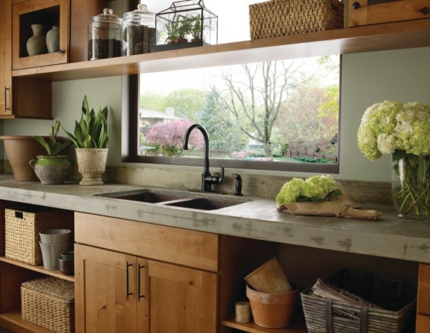 Sur la photo: un intérieur de cuisine en bois avec un évier sur le côté opposé de la fenêtre