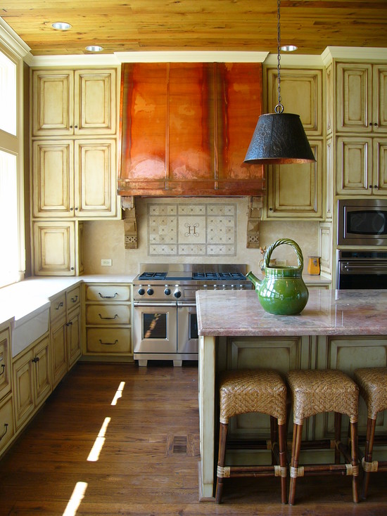 Sur la photo: l'intérieur de la cuisine avec un arbre miteux et une hotte en cuivre